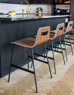 four chairs are lined up in front of an island with bookshelves on it