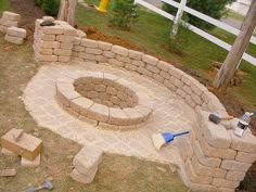 an outdoor fire pit surrounded by bricks