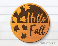 a wooden sign that says hello fall with leaves around it and the words made by sannn