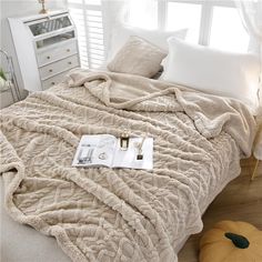 a bed with a blanket and pillows on top of it