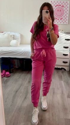 a woman taking a selfie in her pink pajamas and white tennis shoes while standing in front of a mirror