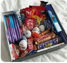 a box filled with candy on top of a bed