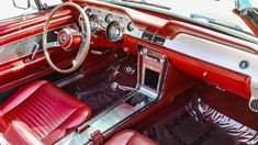 the interior of an old car with red leather seats and dash board, including steering wheel