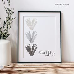 a baby's hand and foot prints are displayed on a shelf next to a potted plant