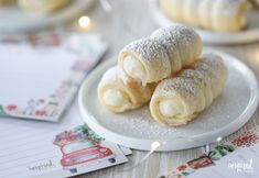 three pastries on a white plate next to christmas cards