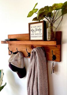 there is a potted plant and two hats hanging on the wall next to a coat rack