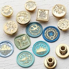 many different types of buttons on a white surface with gold and blue trimmings