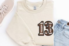 Kid's Embroidered Football Hoodie, Custom Football Number Sweatshirt, Children's Football Team Sweatshirt, American Football Sweatshirt ⭐⭐ Atlascustomtees ⭐⭐ ⭐     Sweatshirts and Hoodies: 8-ounce, 50/50 cotton/poly.              T-Shirts:  6-ounce, 100% combed ring spun cotton, which is a ticker garment that would hold the stitches.              Polo T-Shirts: 6 oz./yd²- 6.5 oz./yd² ring-spun US cotton ⭐   Shipping: Ground Advantage shipping 2-5 business day. For express shipping you should upg Sporty Embroidered Long Sleeve T-shirt, Varsity T-shirt With Embroidered Graphics For Fall, Sporty Long Sleeve T-shirt With Letter Embroidery, Sporty Long Sleeve Embroidered T-shirt, Varsity Long Sleeve T-shirt With Embroidered Logo, Varsity Long Sleeve Hoodie With Embroidered Graphics, College Hoodie With Embroidered Graphics, College Embroidered Graphics Hoodie, Winter Fan Apparel Sweatshirt With Embroidered Logo