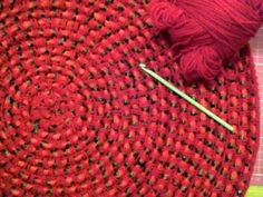 a red piece of yarn with a knitting needle next to it