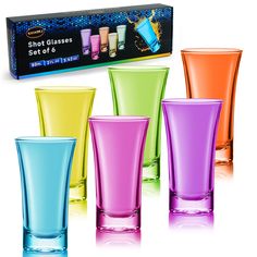 four different colored shot glasses sitting next to each other