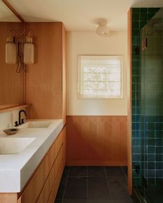 a bathroom with two sinks and a shower