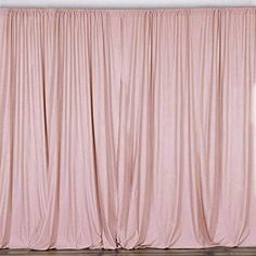 a pink curtain is hanging in front of a white wall