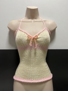 a female mannequin wearing a pink and white top with a bow on it