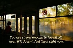 a person sitting on a bus looking out the window at trees and street in the distance