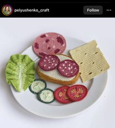 a white plate topped with different types of crochet appliques on top of each other