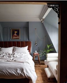 a bedroom with blue walls and white bedding