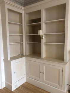 an empty living room with built in bookcases