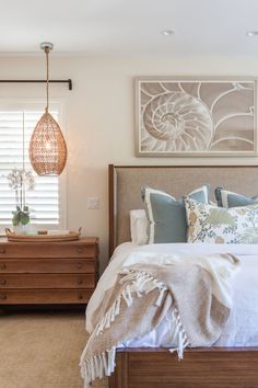 a bedroom with a bed, dresser and two lamps on either side of the bed