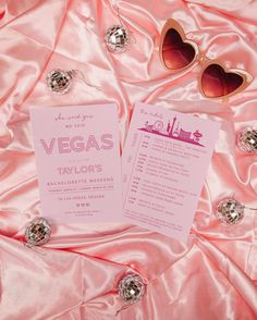 the las vegas bachelor party game is set up on pink satin with sunglasses and jewelry