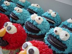 cupcakes decorated with blue and red frosting are lined up on a table