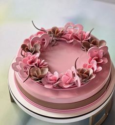 a pink cake decorated with flowers and leaves