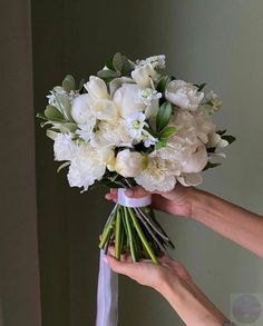 a person holding a bouquet of white flowers