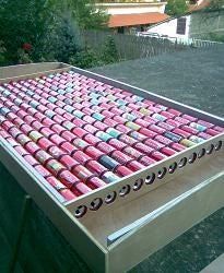 a box filled with lots of pink and green cans sitting on top of a table