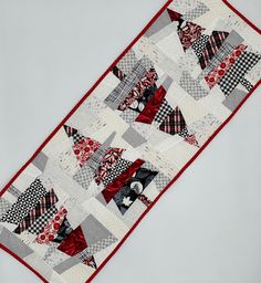 a patchwork table runner with red, black and white designs