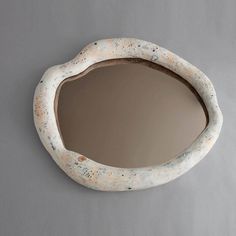 an oval shaped mirror with speckled paint on it