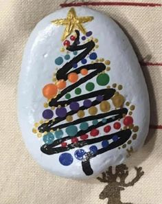 a painted rock with a christmas tree on it