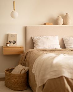 a bedroom with a bed, nightstands and baskets on the side table in front of it