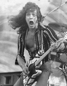 a man with his mouth open while playing an electric guitar