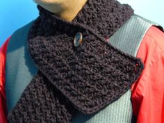 a close up of a person wearing a crocheted neck scarf with buttons on it