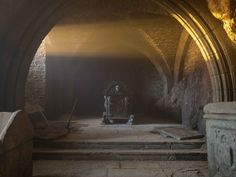 an underground tunnel with stairs leading to the entrance and light coming in from behind it