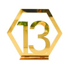 the number thirteen is displayed in front of a white background with gold foil on it