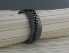 a baseball ring sitting on top of a sheet of white paper with black stitching