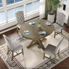 a dining room table with chairs and plates on the table in front of a large window