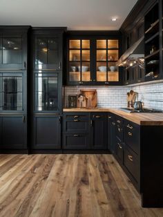 a kitchen with black cabinets and wooden floors is pictured in this image, it appears to be empty