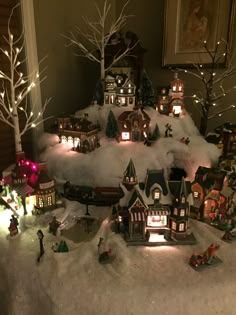 a christmas village is lit up in the snow