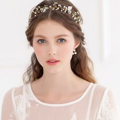 a woman wearing a white dress and a gold headpiece with flowers on her hair