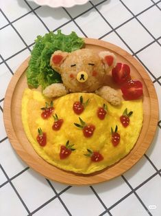 a teddy bear sitting on top of an omelet