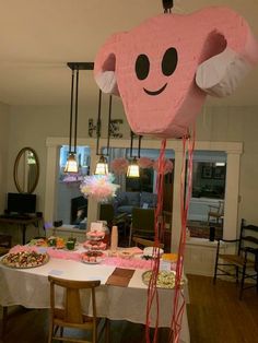 a table with some food on it and a large pink object hanging from the ceiling