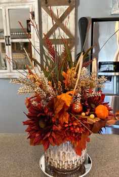 a vase filled with lots of flowers on top of a counter