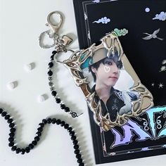 a keychain with a photo on it sitting next to a card and beaded necklace