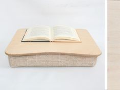 an open book sitting on top of a wooden table next to a white wall with wood trim