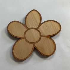 a wooden flower shaped object on a white surface