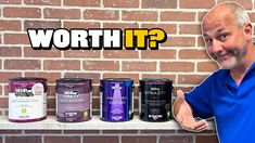 a man standing in front of a brick wall with five different types of paint