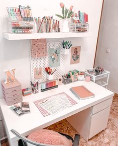 a white desk topped with lots of crafting supplies next to a wall mounted shelf