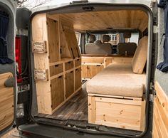 the interior of an empty van with wooden furniture in it's back door area