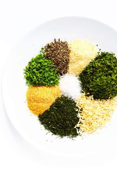 four different types of spices on a white plate